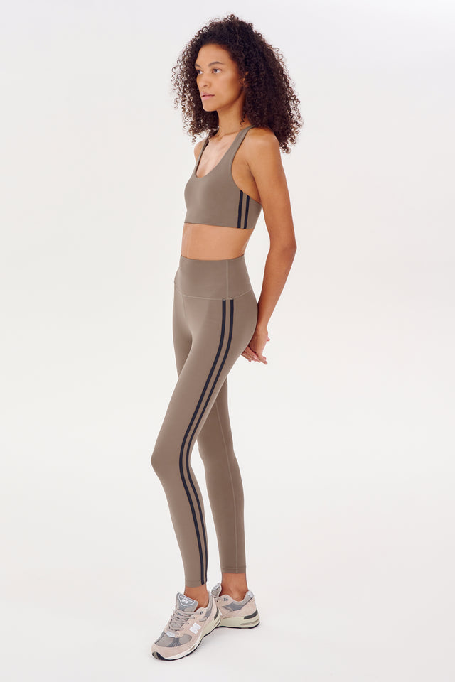 A woman in a SPLITS59 racer back bra and sports outfit, ideal for hot yoga.