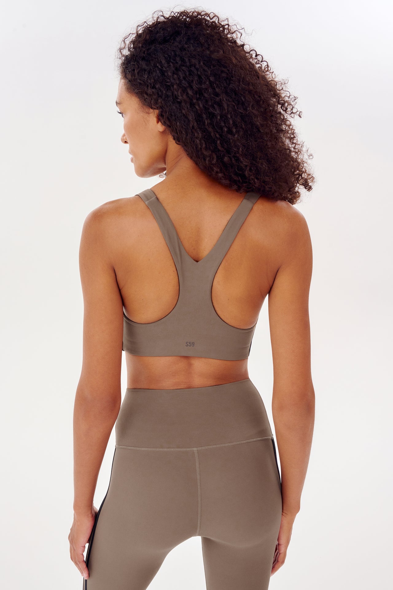The back view of a woman wearing a grey racer back bra from the SPLITS59 Ella Airweight Bra - Lentil/Black collection.