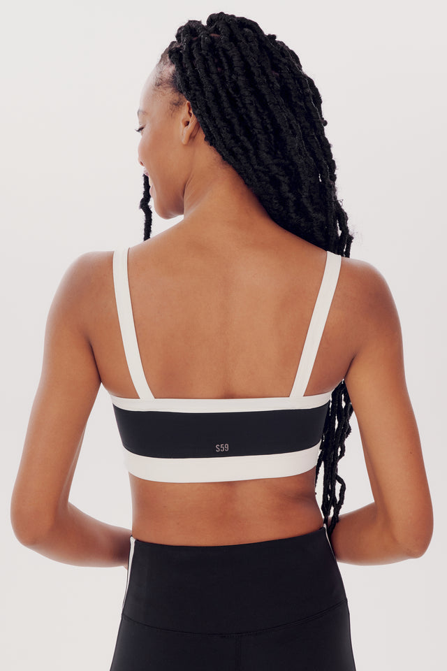 Woman with braided hair wearing a SPLITS59 Monah Rigor Bra in Black/White and leggings, viewed from the back against a white background.