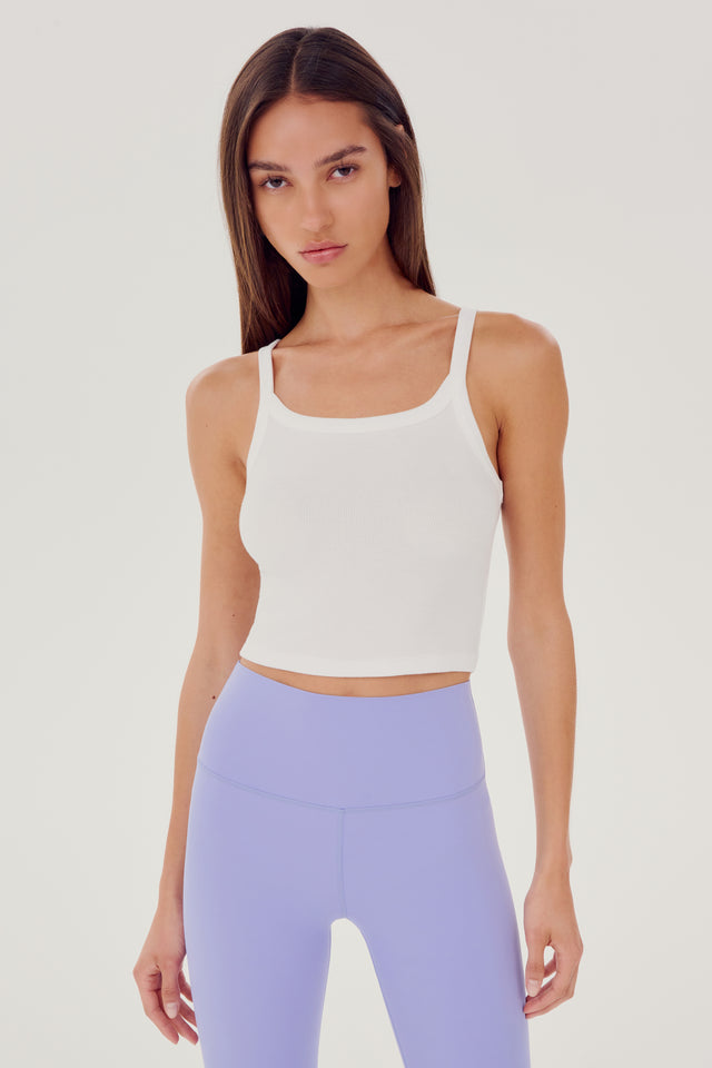 Front view of girl wearing white ribbed square neck cropped tank top with light purple leggings