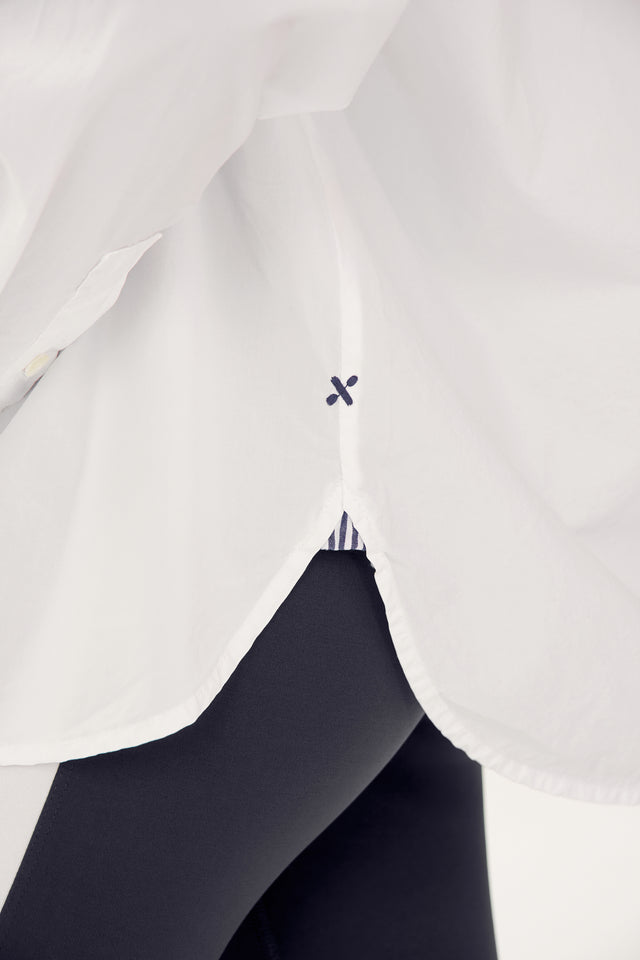 A close-up view of a person wearing an oversized Alex Mill x Splits59 Jo Shirt - White with a small black detail and black pants.