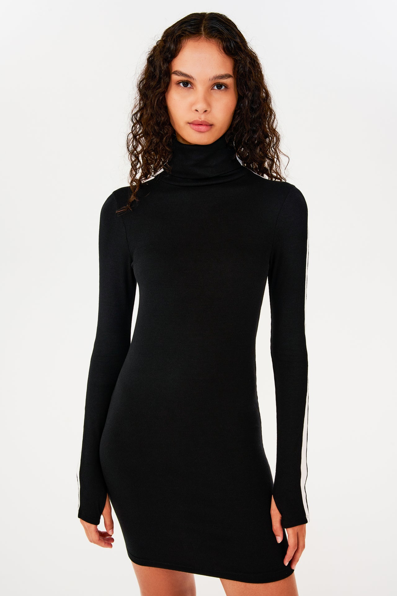A woman wearing a black SPLITS59 Jackson Rib Turtleneck dress.