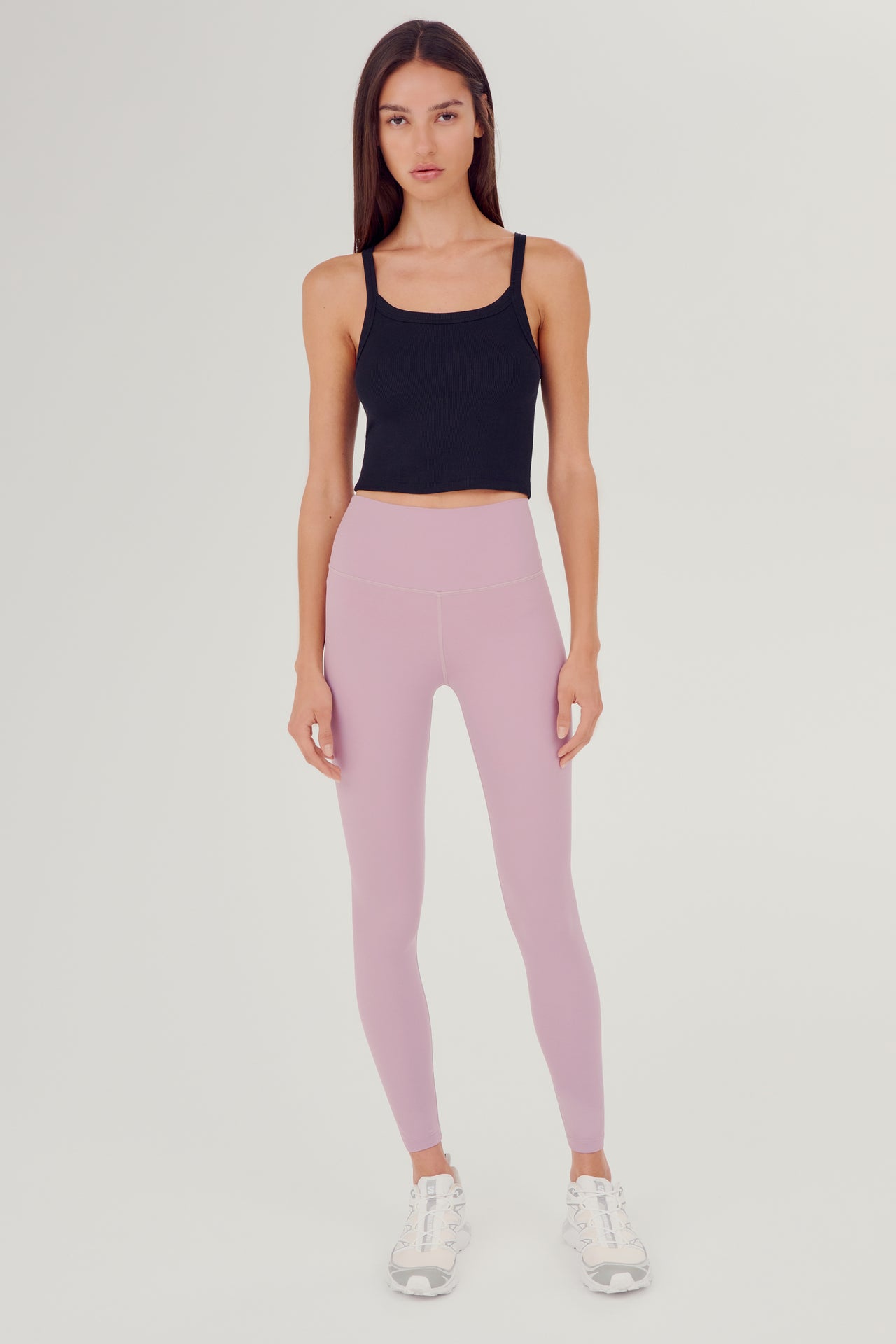 Full front view of girl wearing black ribbed square neck cropped tank top with light pink leggings and white shoes