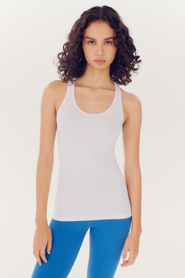 Woman in a Splits59 Ashby Rib Tank - White and blue leggings standing against a white background, looking directly at the camera.