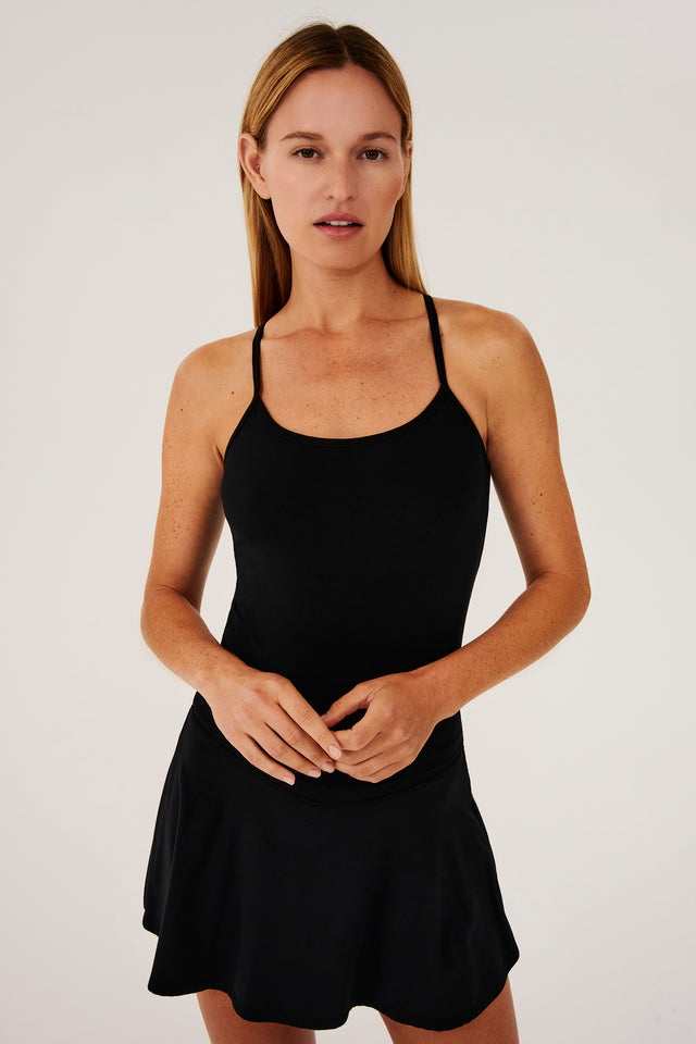 Front view of girl wearing black spaghetti strap tank top with black skirt
