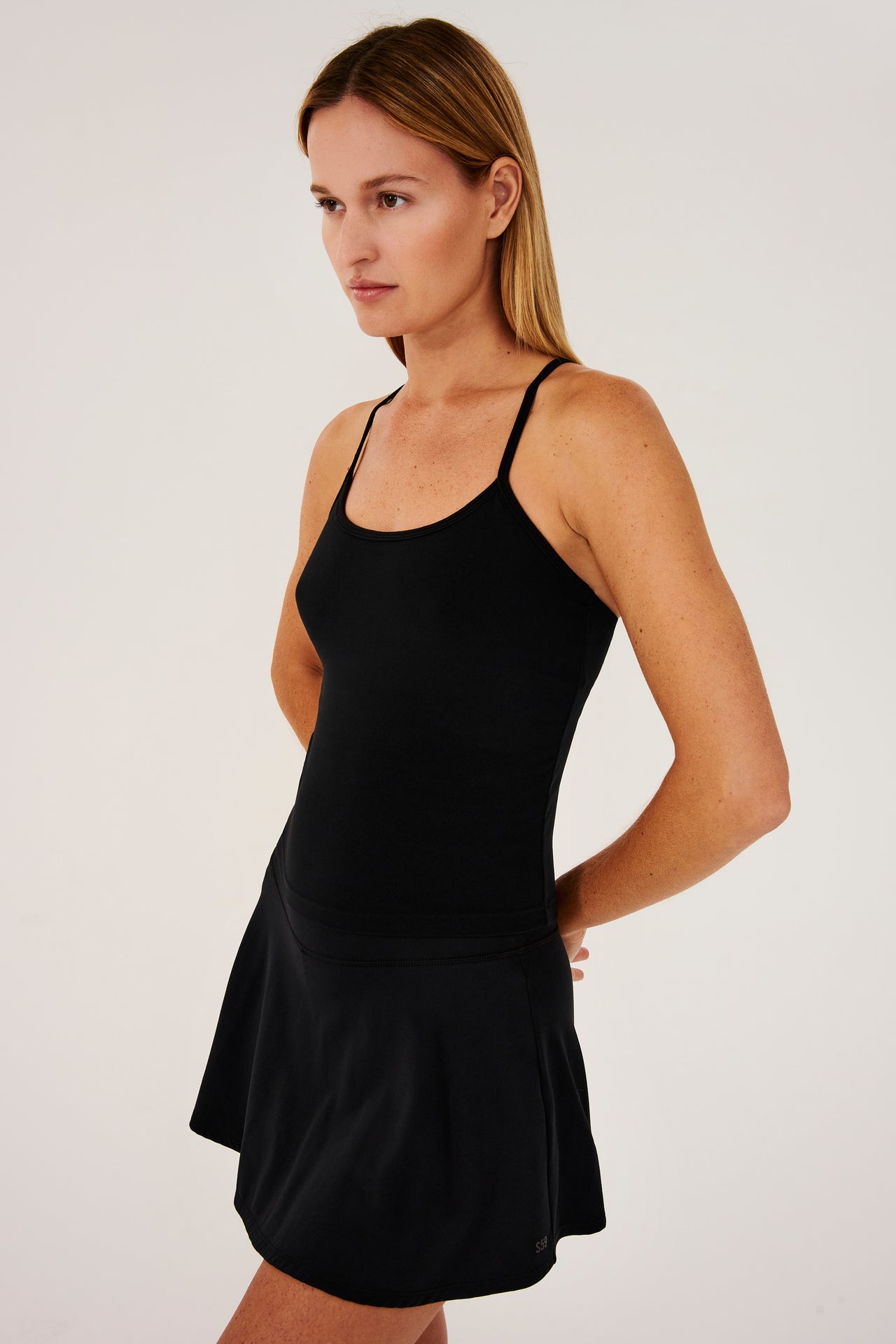 Side view of girl wearing black spaghetti strap tank top with black skirt