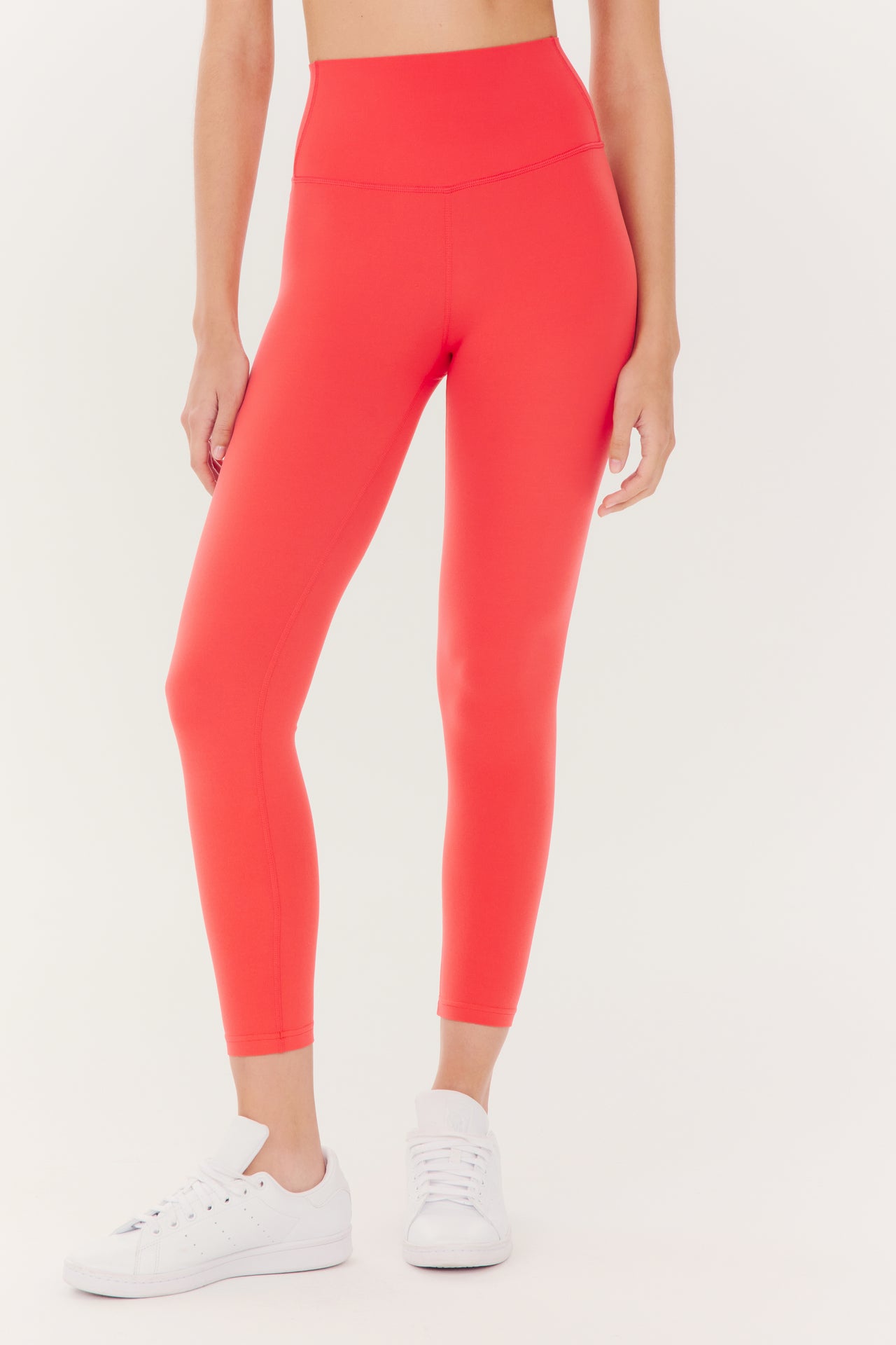 Woman wearing red Airweight High Waist Legging in Melon by SPLITS59 and white sneakers.