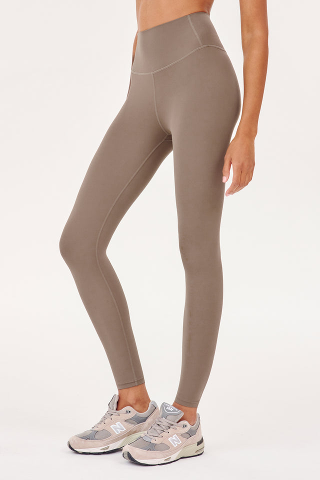 The back view of a woman wearing SPLITS59's Airweight High Waist Legging in Lentil.
