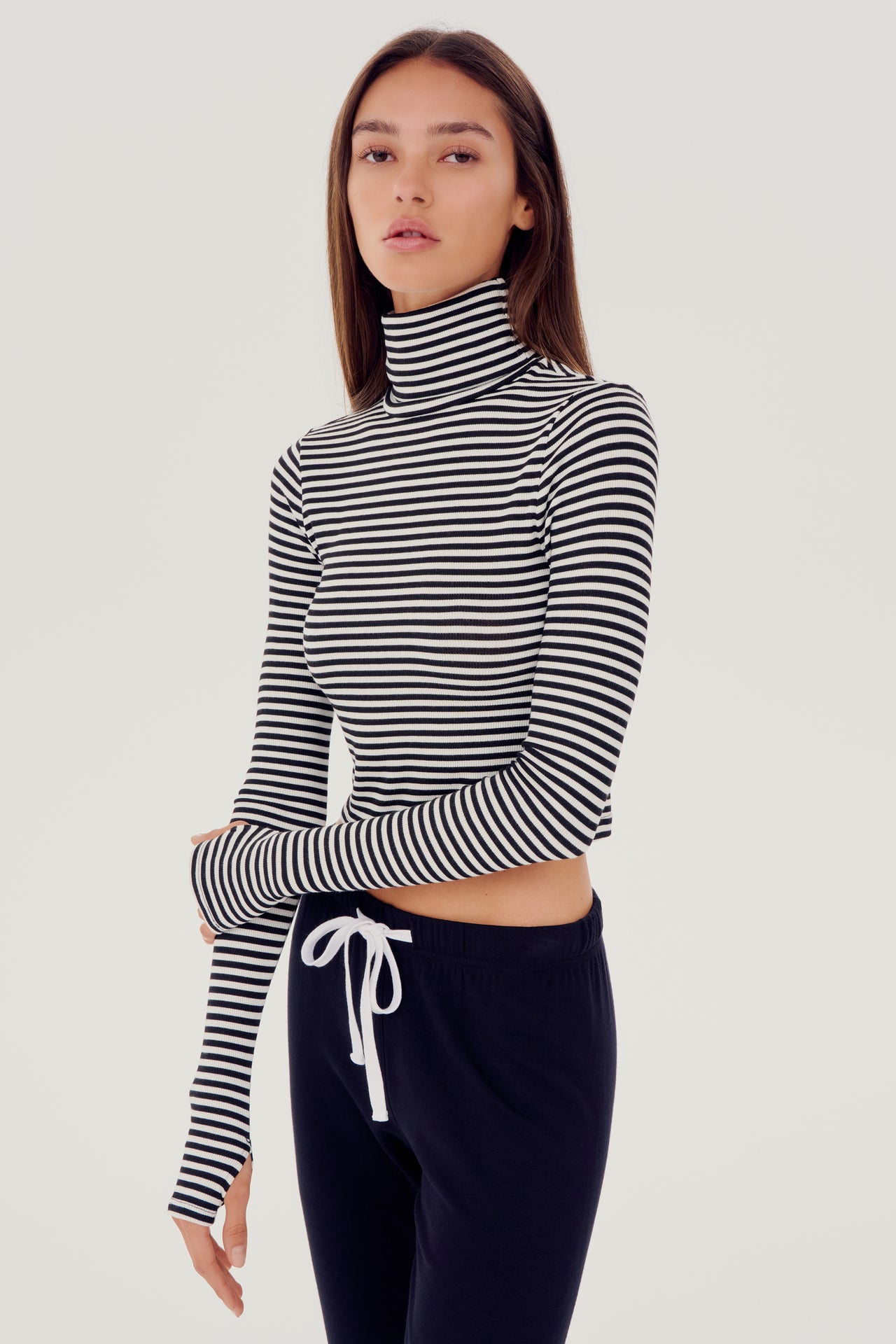 The model is wearing a black and white striped SPLITS59 Jackson Rib Cropped Turtleneck top.
