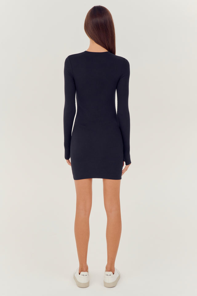 The back view of a woman wearing a SPLITS59 Louise Rib Long Sleeve Dress in Black.