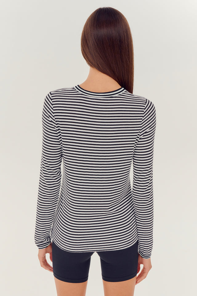 The back view of a woman wearing the SPLITS59 Louise Rib Long Sleeve - White/Black Stripe top suitable for yoga.