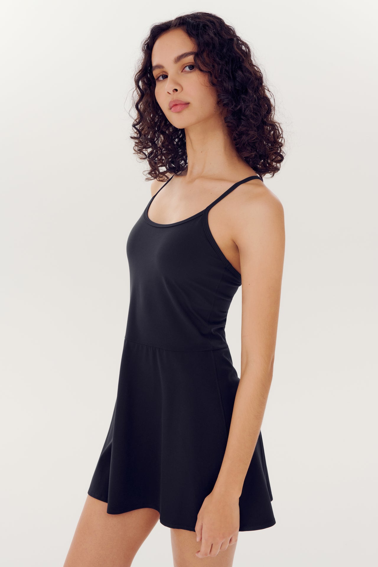 A woman in a SPLITS59 Simona Airweight Tank Dress - Black posing against a white background.