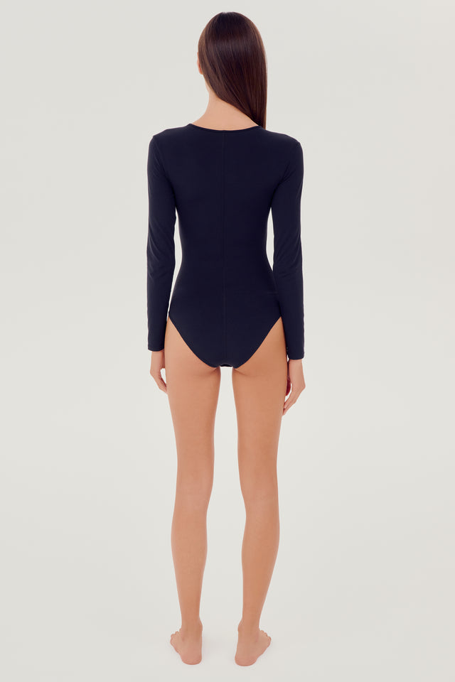 Full back view of girl wearing black long sleeve one piece