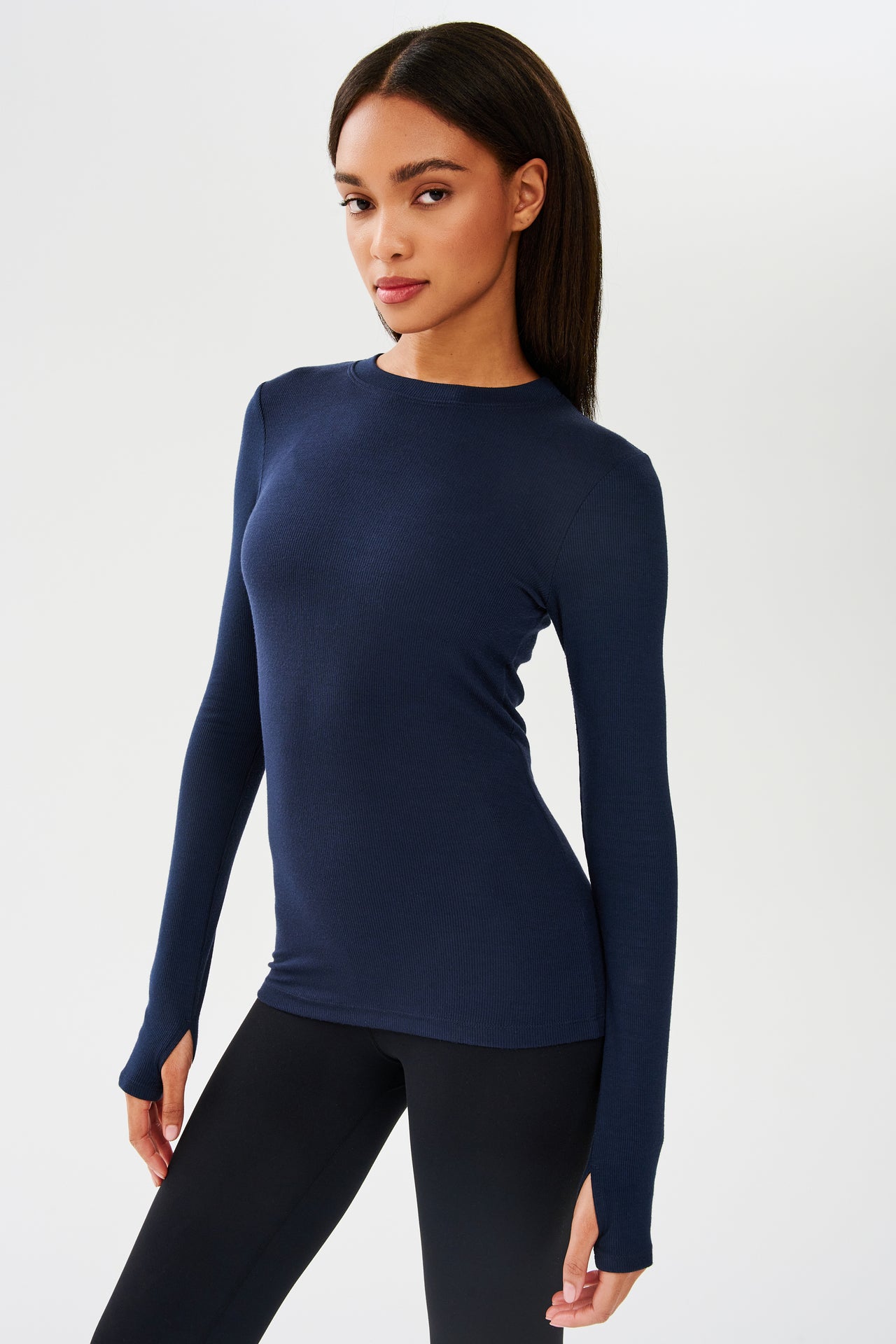 A woman in a blue Louise Rib Long Sleeve from SPLITS59 doing yoga.