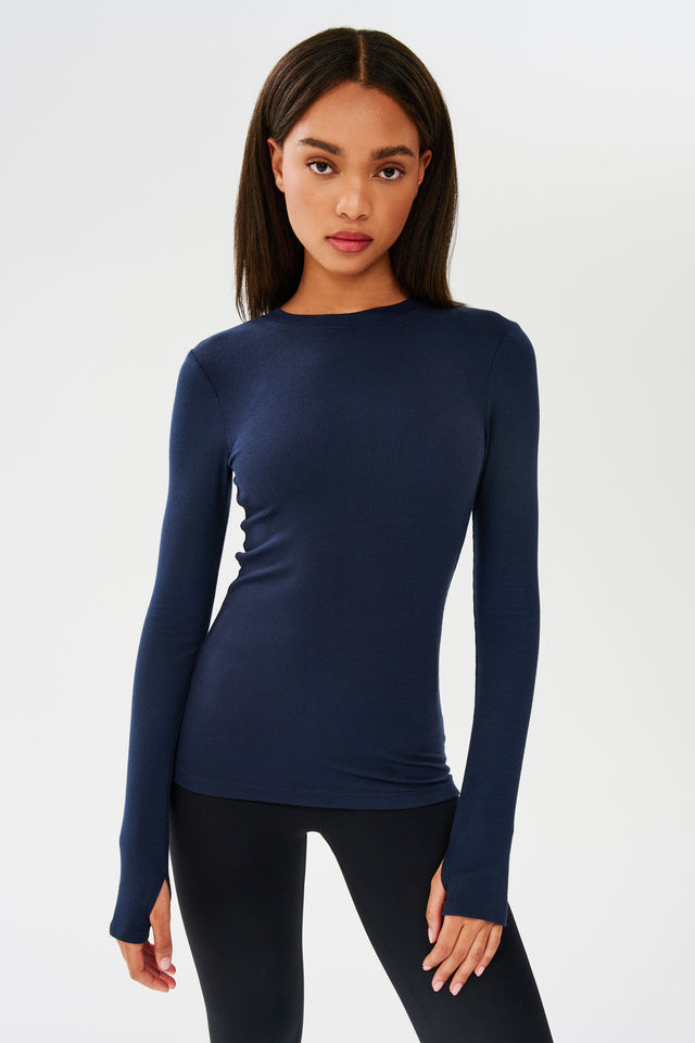 The model is wearing a SPLITS59 Louise Rib Long Sleeve - Indigo for gym workouts.