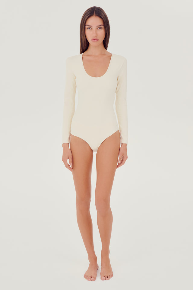 Full front view of girl wearing white long sleeve one piece