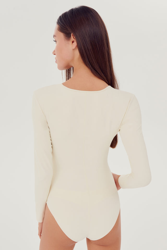 Back view of girl wearing white long sleeve one piece