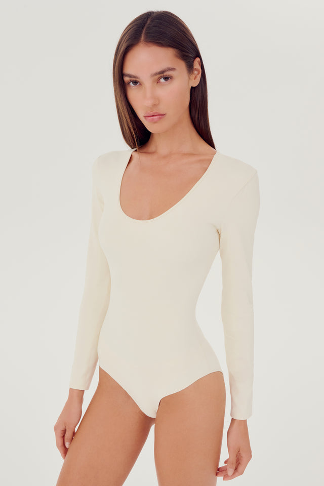Side view of girl wearing white long sleeve one piece