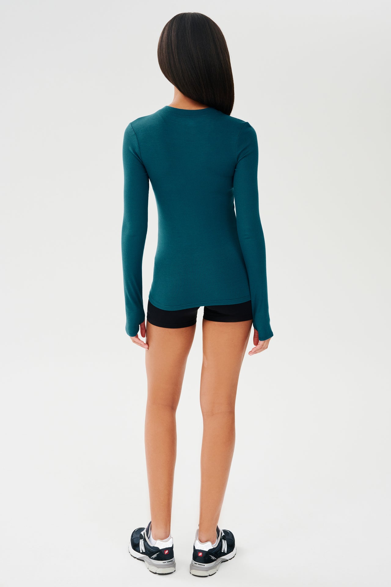 The back view of a woman wearing a SPLITS59 Louise Rib Long Sleeve - Peacock top made of modal and spandex.