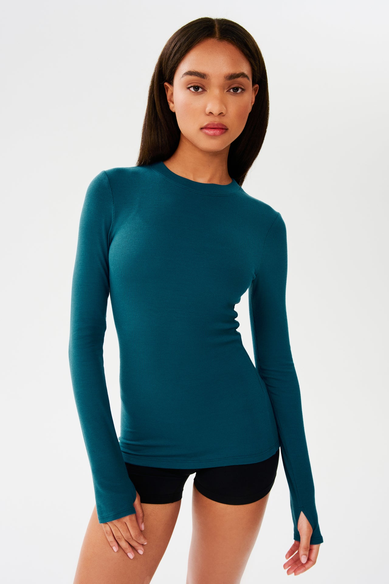 The model is wearing a Louise Rib Long Sleeve - Peacock top made of modal and spandex from SPLITS59.