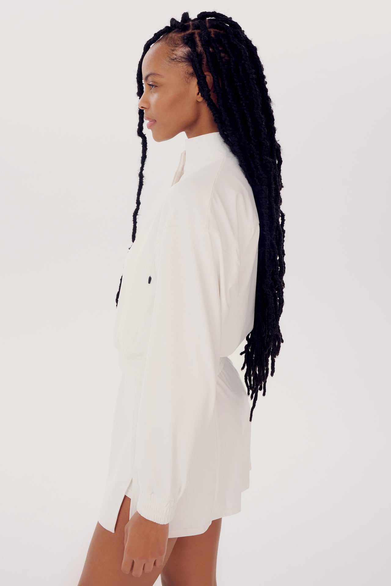 Sentence with replaced product:

Profile view of a woman with long braids wearing a SPLITS59 Harlowe Rigor Jacket in White against a plain background.