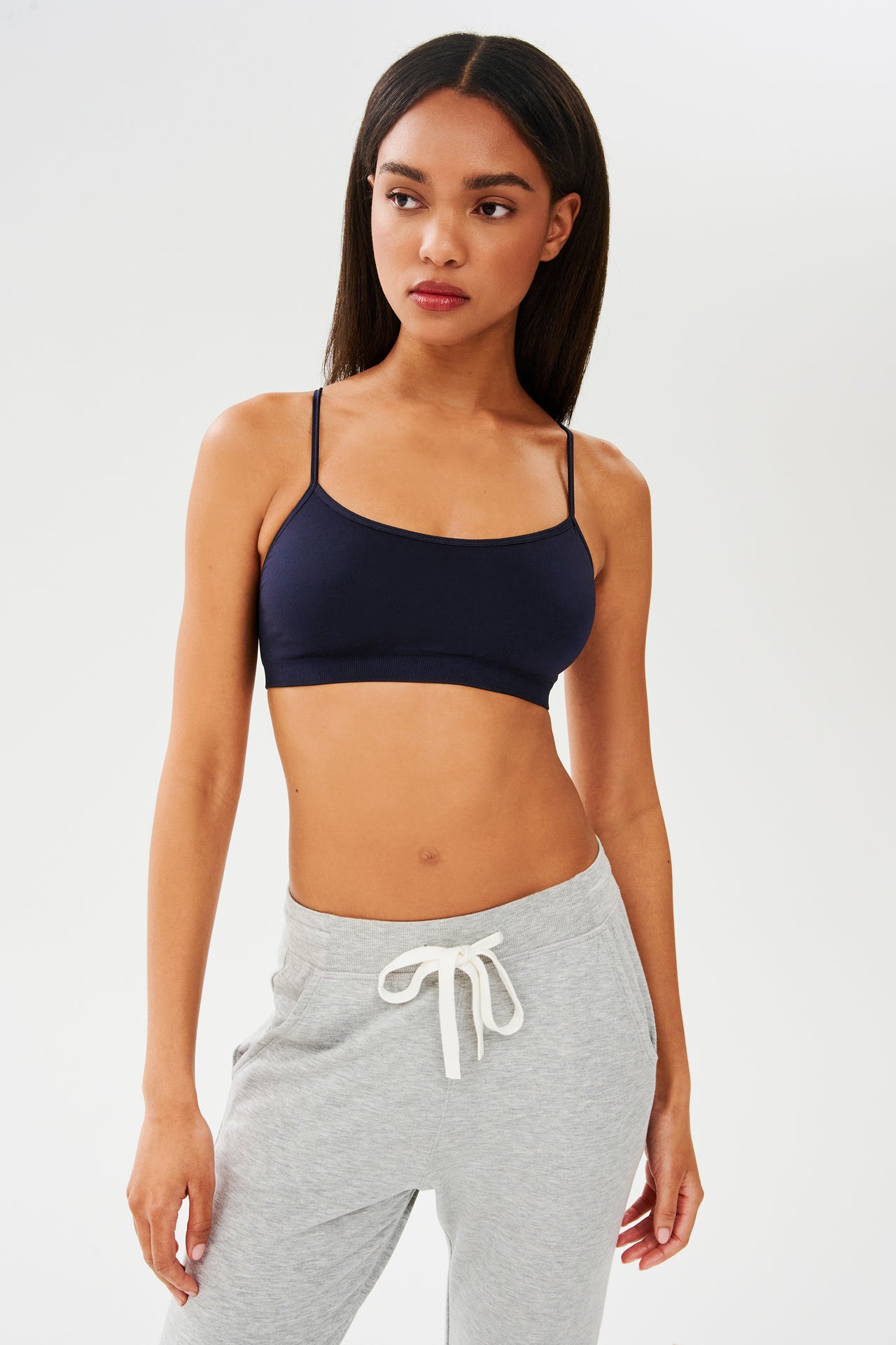The model is wearing a Loren Seamless Bra in Indigo and grey sweatpants from SPLITS59, ideal for gym workouts.