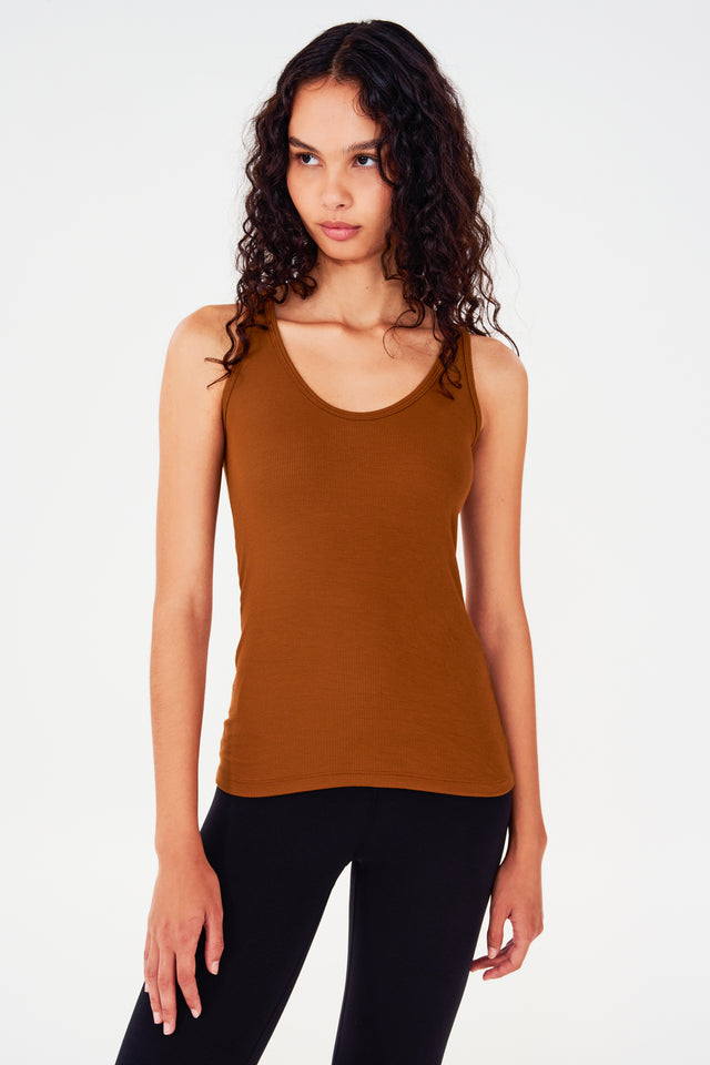 Front view of girl wearing a reddish brown tank top and black leggings