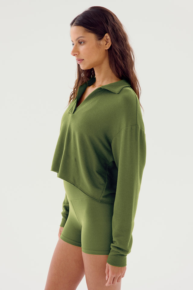 A woman wearing an olive Joan Fleece Polo Sweatshirt from SPLITS59 and matching green shorts, both made from soft MODAL fabric, stands against a plain white background.