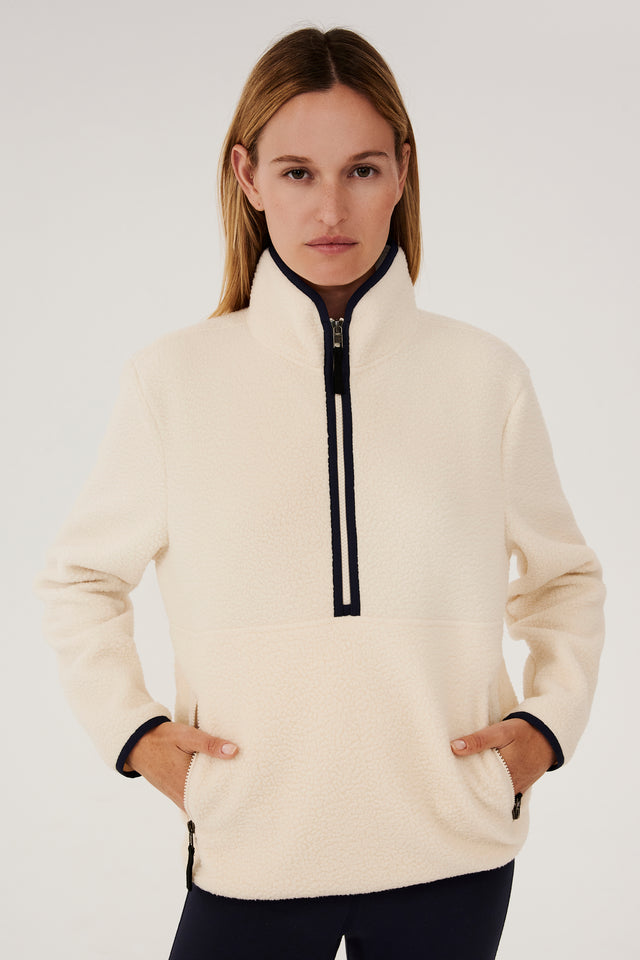 A woman wearing a SPLITS59 Libby Sherpa Half Zip in Creme/Indigo fleece pullover.