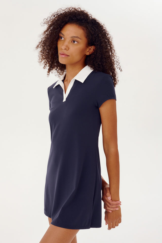 A young woman wearing a Polo Airweight Dress in Indigo by SPLITS59.