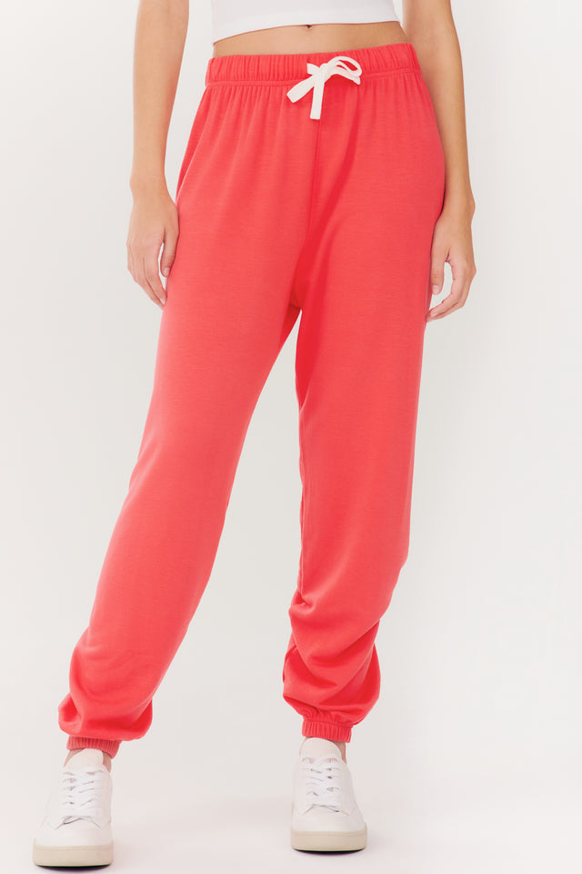 Andie Oversized Fleece Sweatpant - Melon by SPLITS59 and white sneakers on a person against a white background.