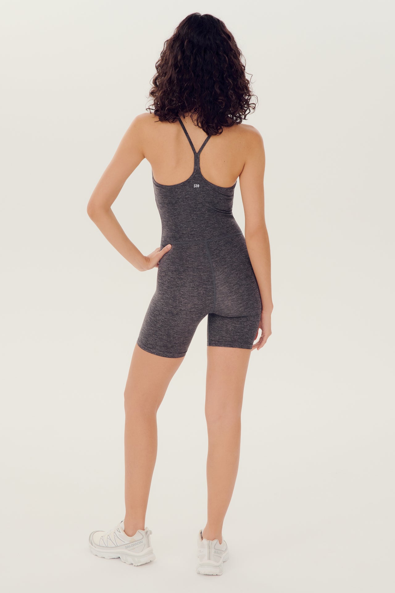 Full back view of girl wearing grey mid thigh spaghetti strap body suit/one piece