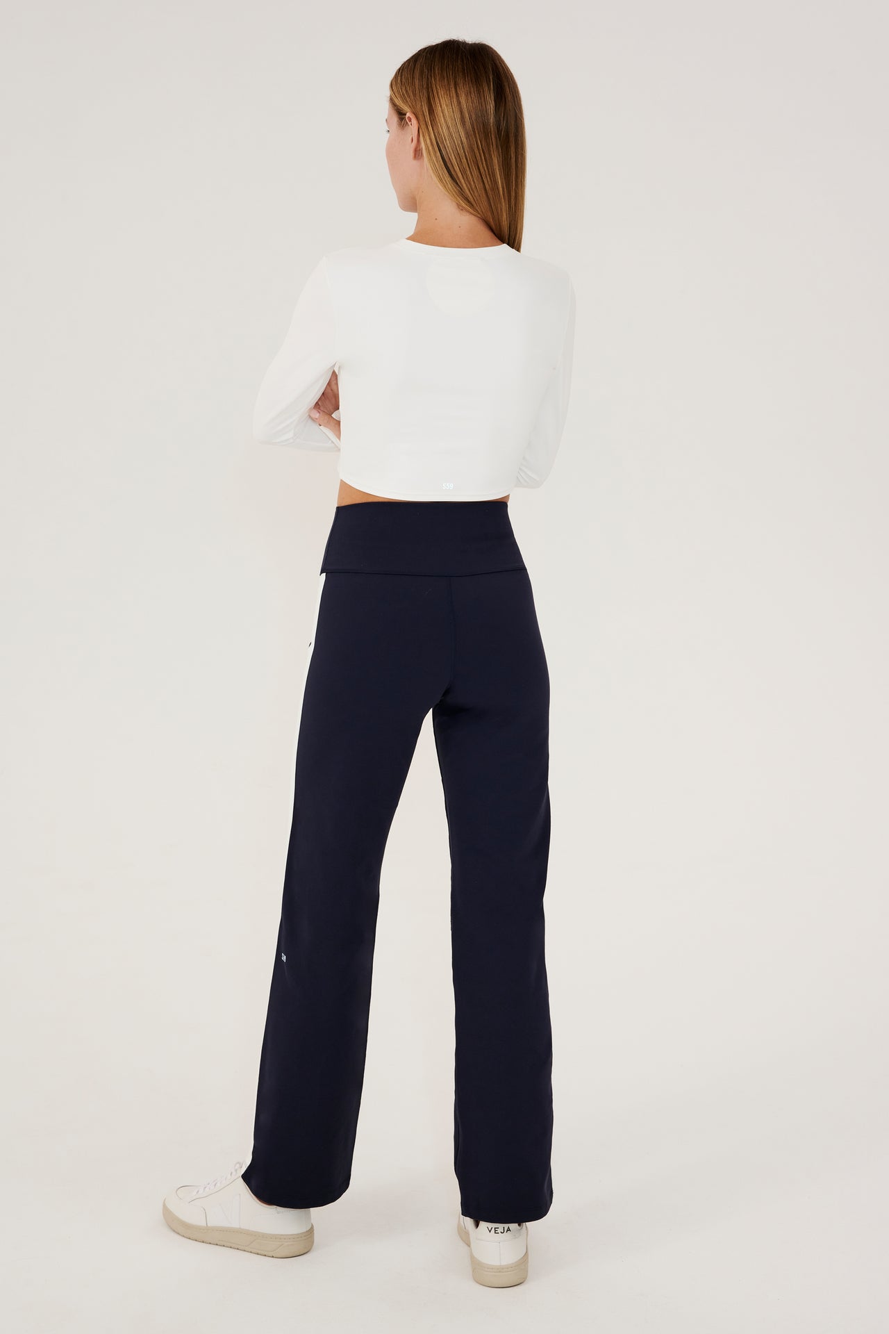 The back view of a woman wearing SPLITS59's Harper Supplex Pant in Indigo/White.