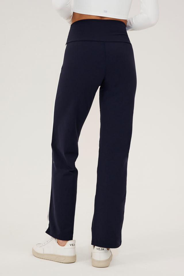 The back view of a woman wearing SPLITS59's Harper Supplex Pant in Indigo/White, perfect for a workout.