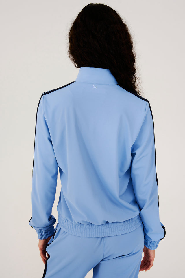 The back view of a woman in a SPLITS59 Fox Techflex Jacket in Jacinthe/Indigo, perfect as an après workout piece.