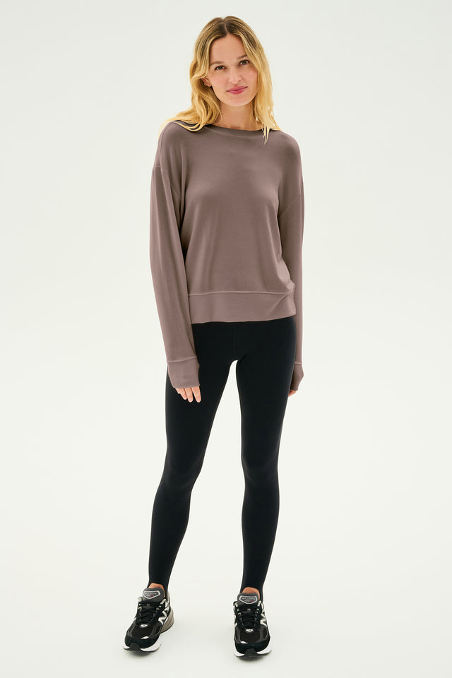 A person stands wearing a Lentil Sonja Fleece Sweatshirt from SPLITS59 and black leggings paired with black sneakers against a plain background. The ultra-luxe fleece of the sweatshirt, MADE IN LOS ANGELES, adds an extra touch of comfort and style.