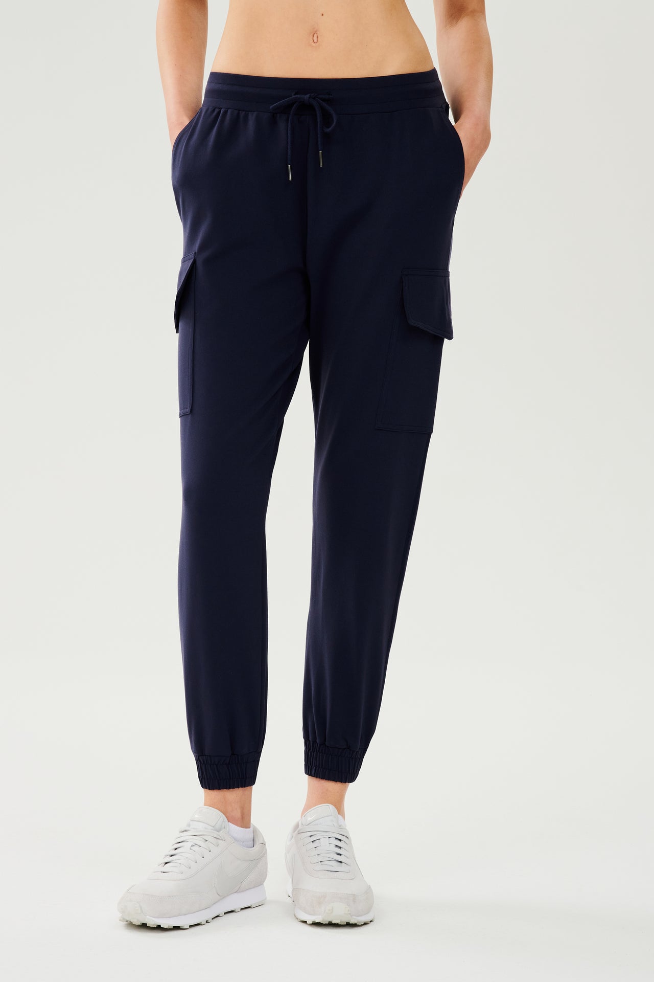 Front view of dark blue cargo pants with white shoes