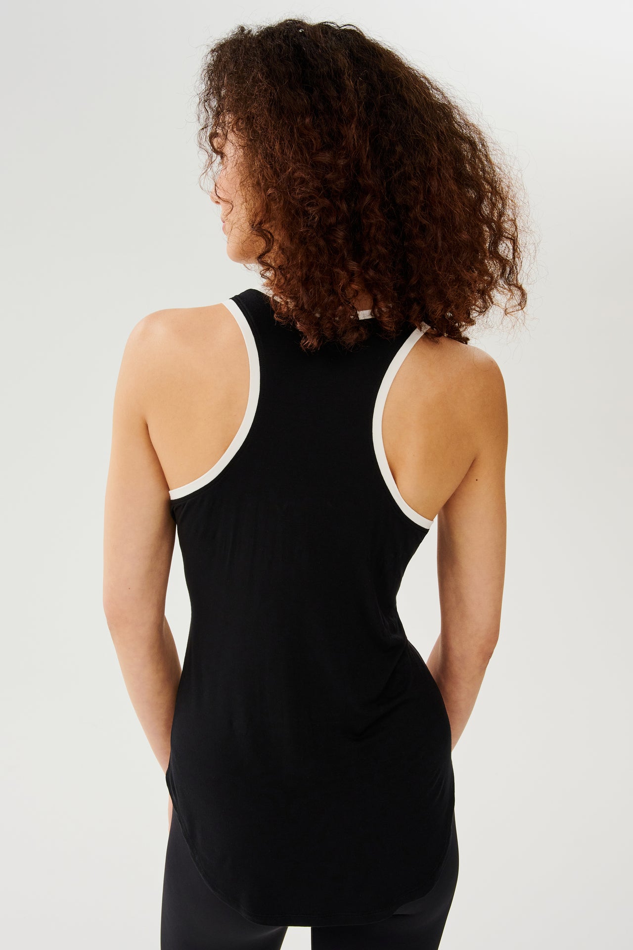 The back view of a woman wearing a SPLITS59 Hana Ringer Tank in Black/White.