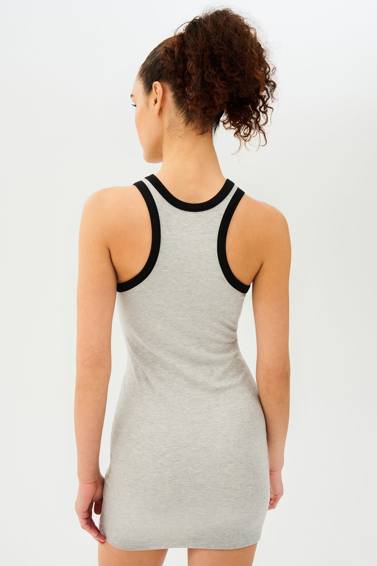 The back view of a woman in a SPLITS59 Kiki Rib Dress - Heather Grey/Black.