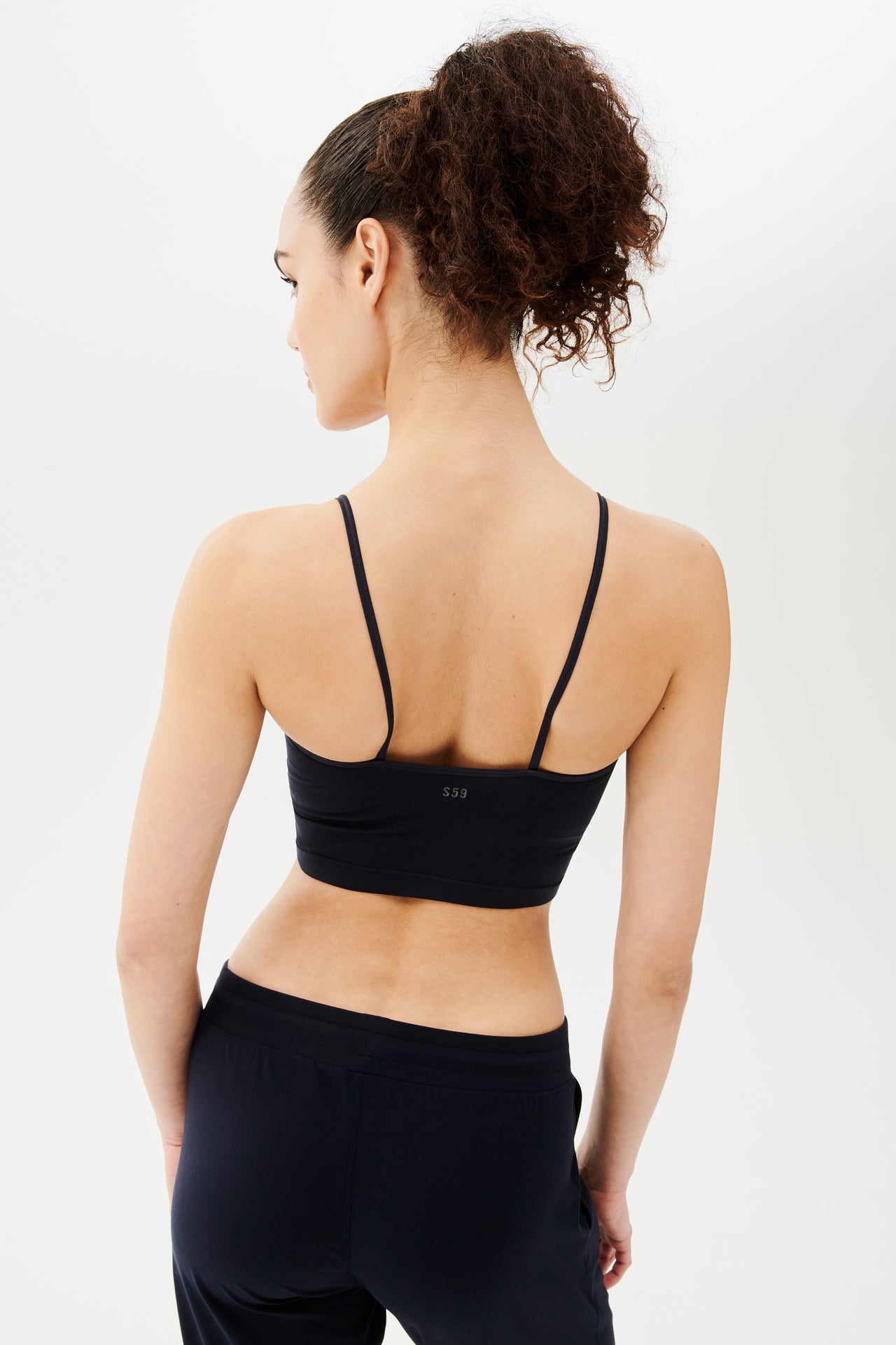 The back view of a woman wearing a Splits59 Loren Seamless Cami in Indigo.