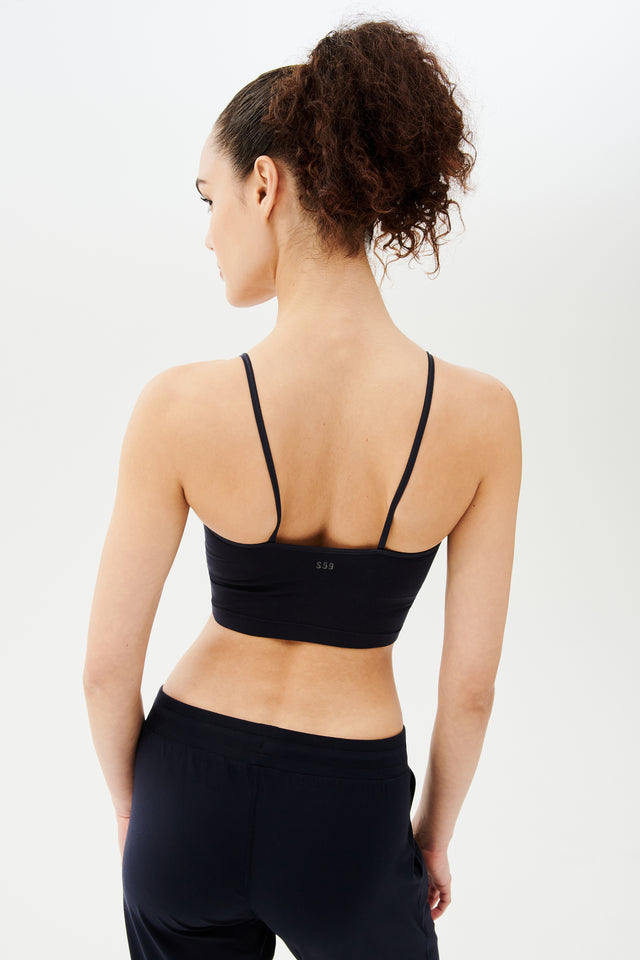 The back view of a woman wearing a Splits59 Loren Seamless Cami in Indigo.