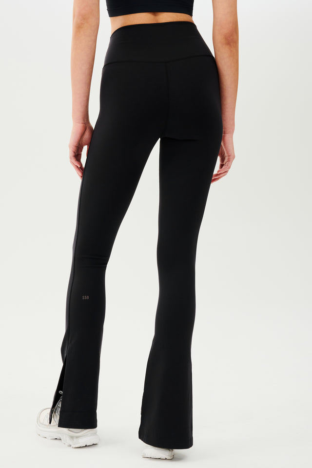 The back view of a woman in black, high waist SPLITS59 Raquel leggings.