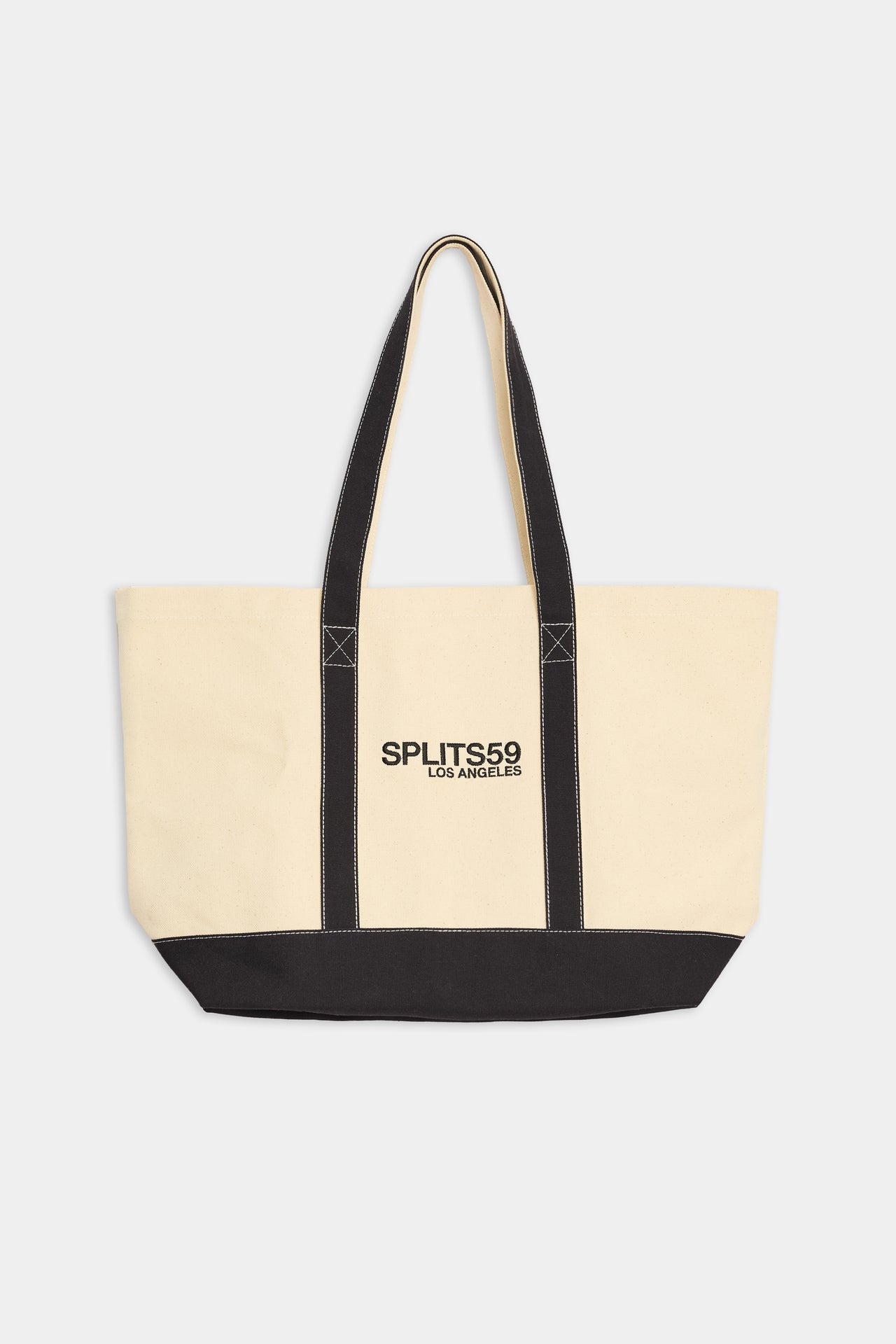 Yellowish white tote bag with black bottom and straps