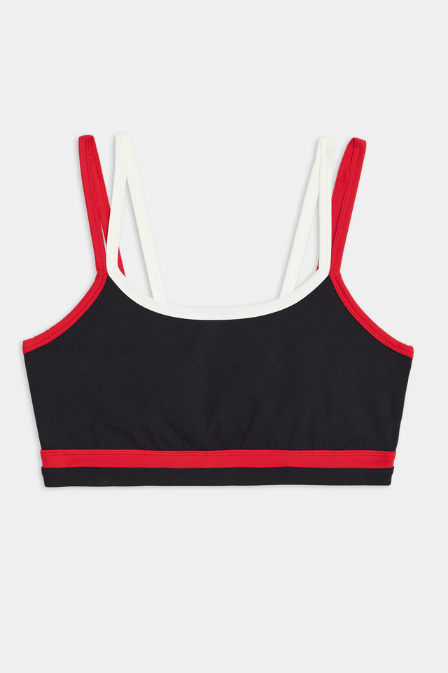 The SPLITS59 Eva Rigor Double Strap Bra - Black/Pirate Red is a black sports bra with red trim and dual shoulder straps, one pair white and one pair red. Designed for running and CrossFit, this bra ensures you feel comfortable and confident during your workouts.