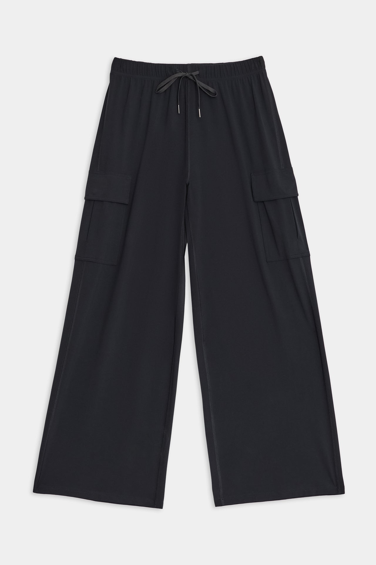 SPLITS59 Alex Airweight Cargo Pant - Black: Black, wide-leg pants with an elastic waistband and drawstring, featuring two large cargo pockets on the sides. Made from a comfortable blend of nylon and spandex, these versatile pants offer both style and durability.