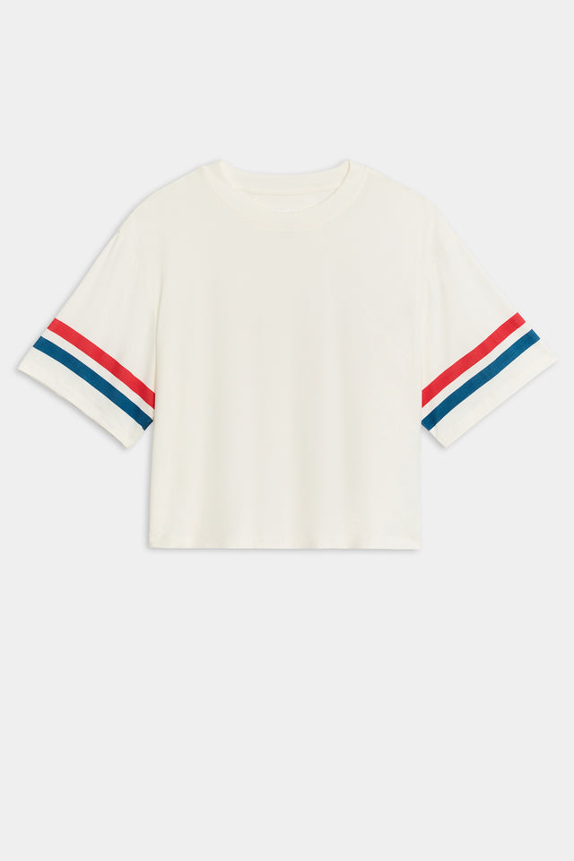 Flat view of a cropped short sleeve white shirt with red and blue stripes on the arm 