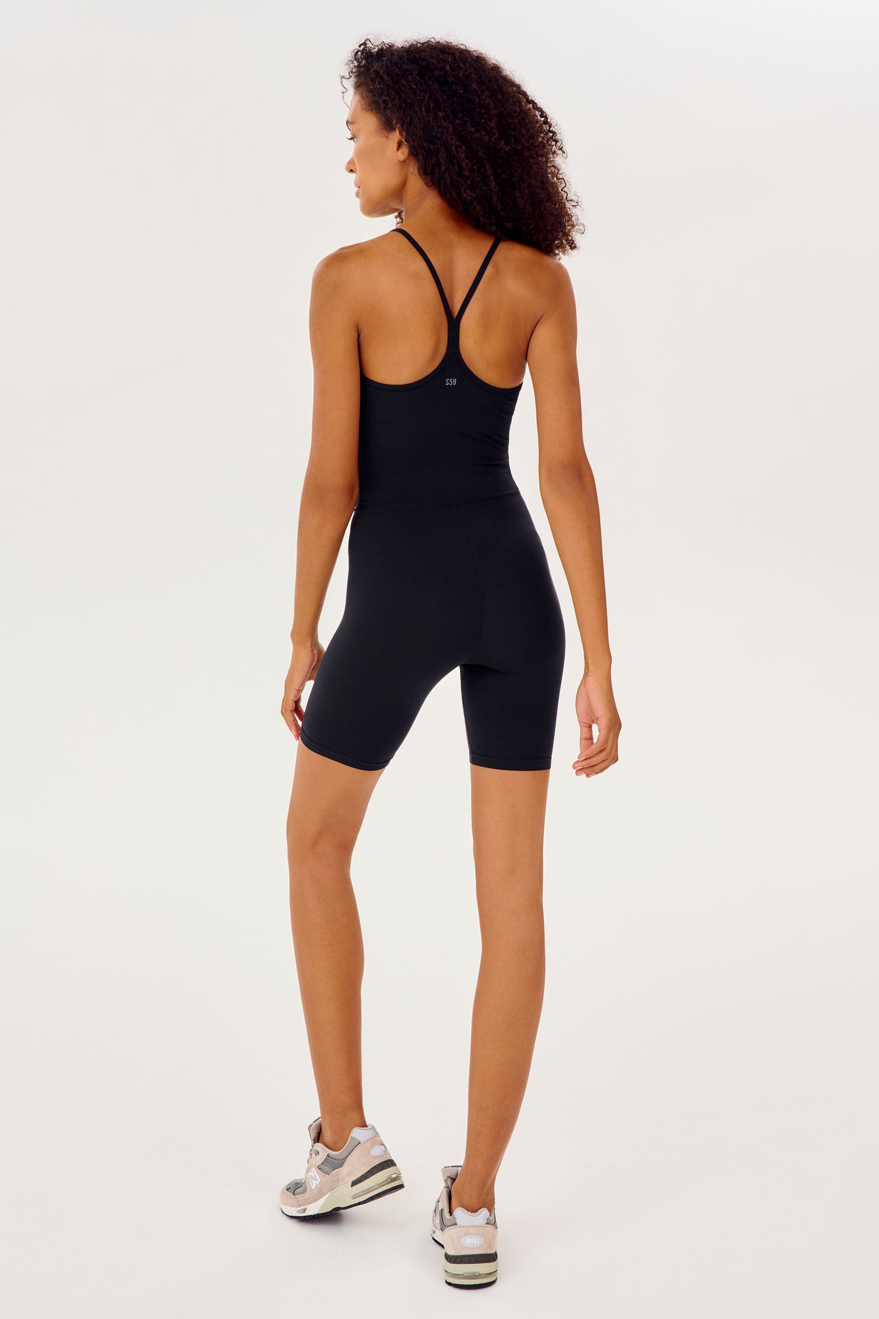 Full back view of black mid thigh spaghetti strap body suit/one piece