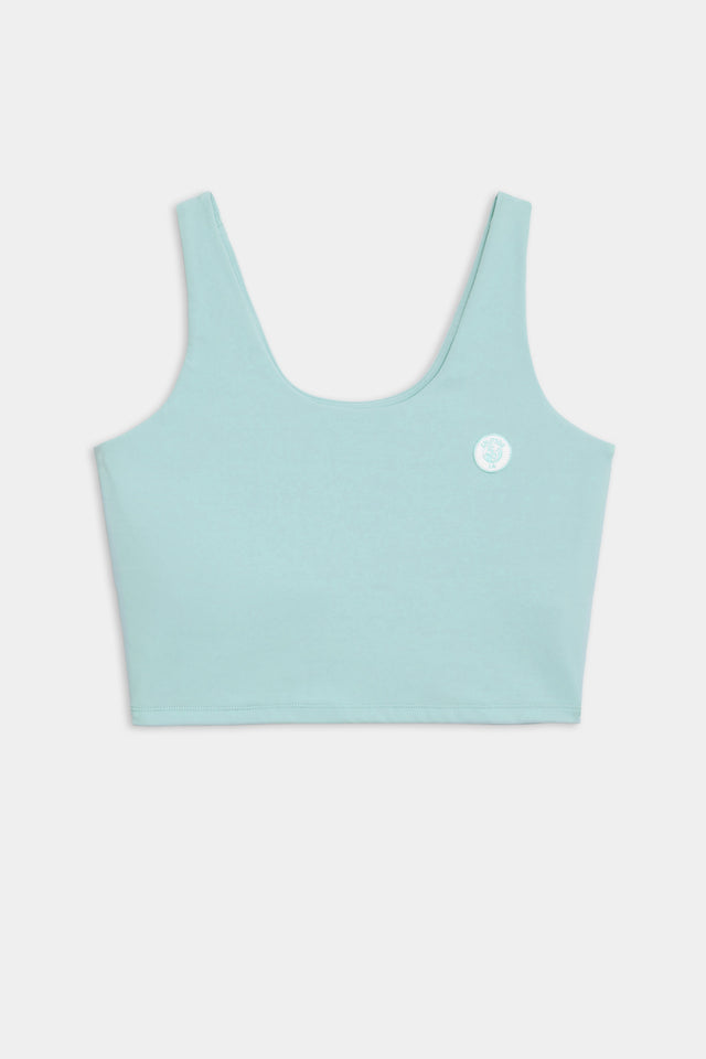 Front flat view of teal tank bra with white logo crest