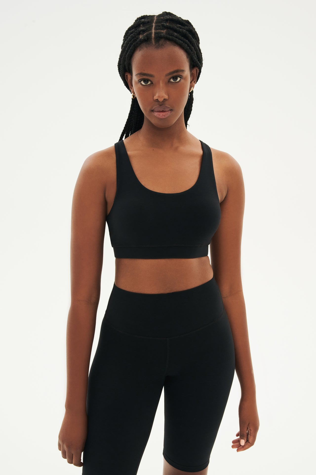 Front view of girl wearing black sports bra and black high waisted bike shorts