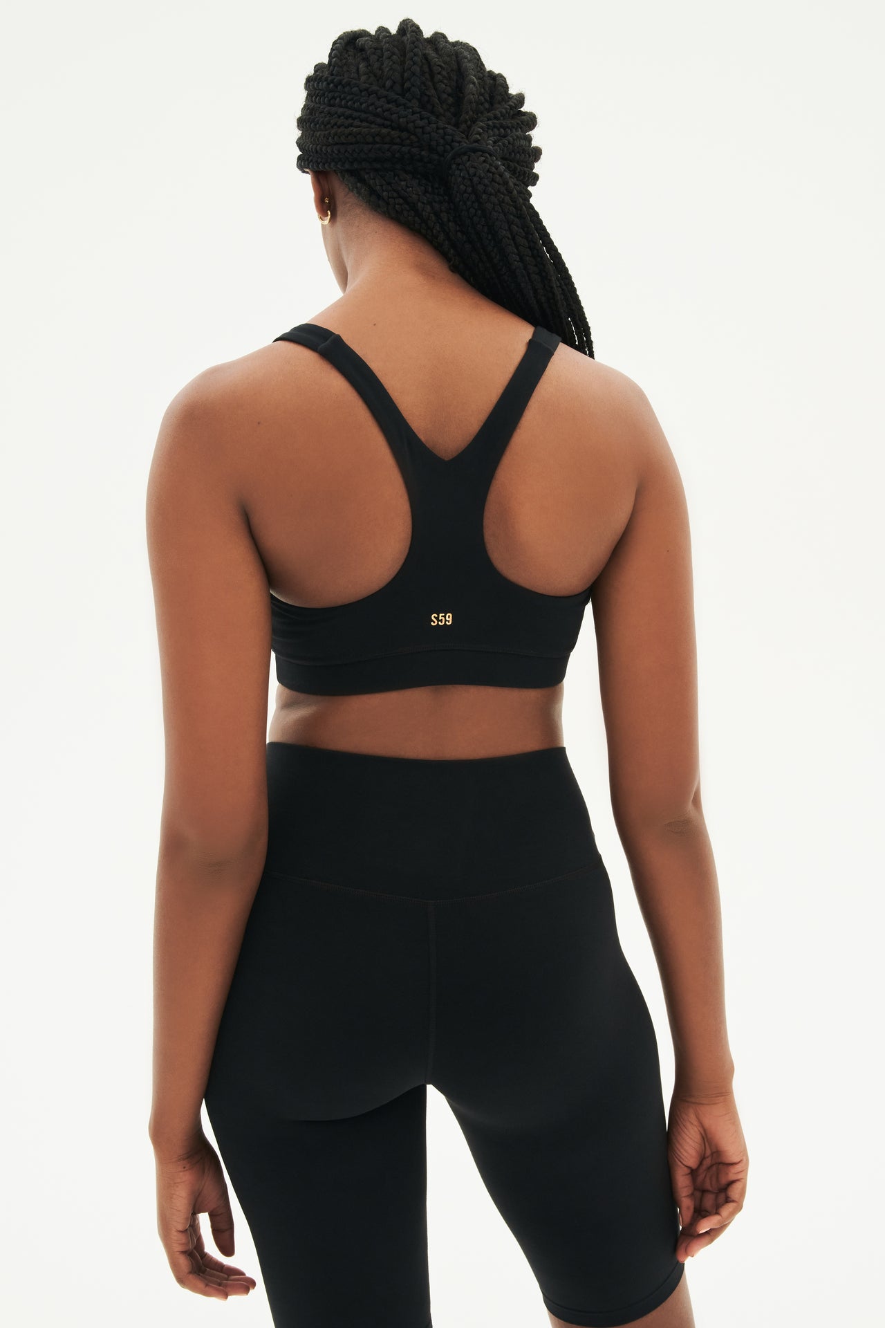 Back view of girl wearing black sports bra and black high waisted bike shorts
